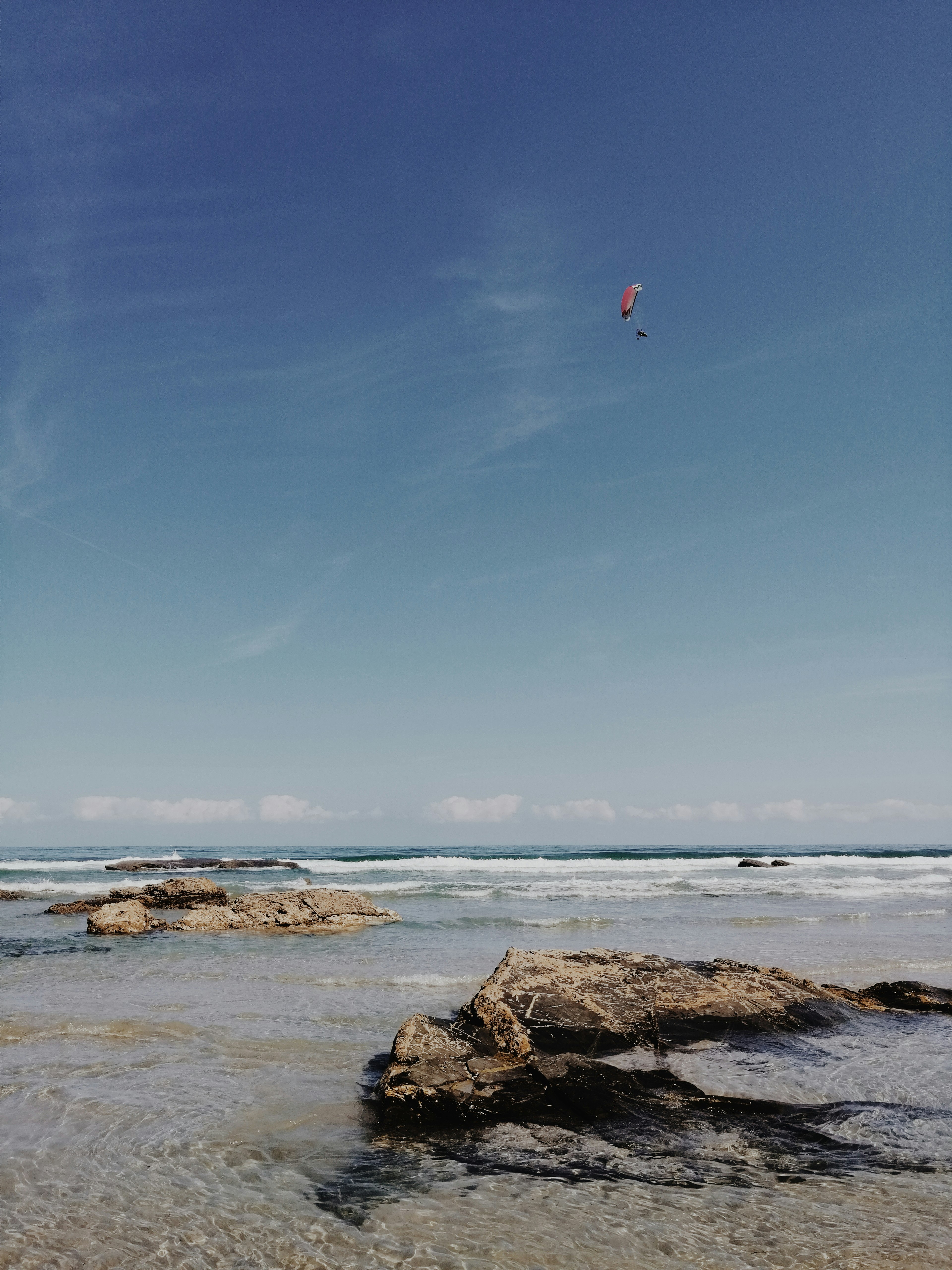 person jumping on rocky shore during daytime